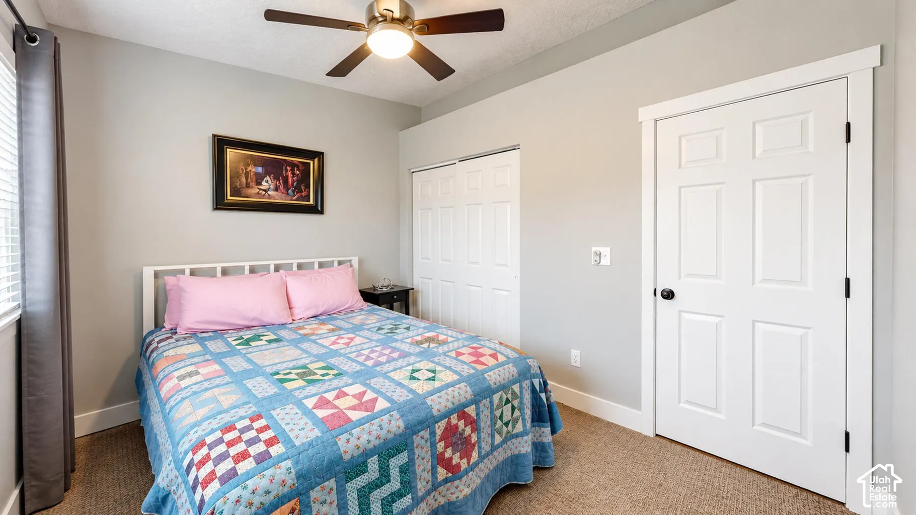 Neutral-toned interior featuring wall-to-wall carpeting, ceiling-mounted light fixture with fan, six-panel interior door, and dual-door sliding closet