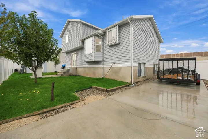 Two-story exterior featuring light-gray horizontal siding, a concrete foundation, bay window architecture, and a concrete driveway