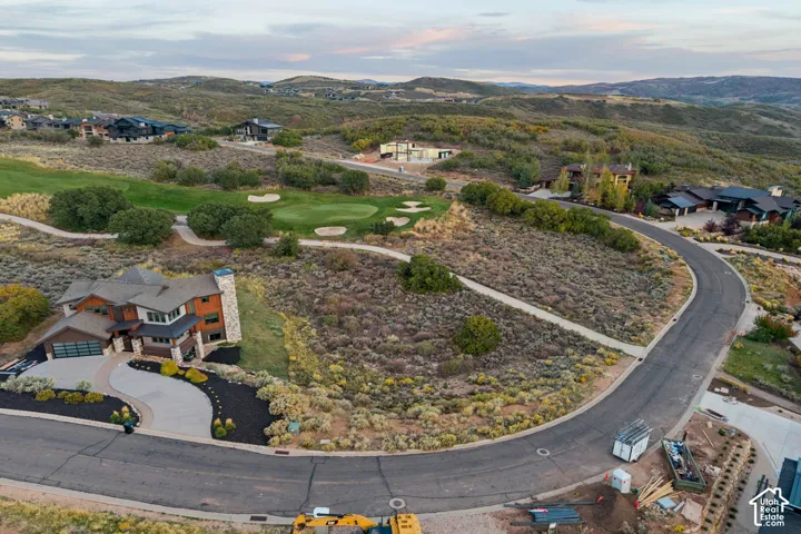 Custom-designed residence featuring a multi-tone exterior, a modern garage door, and an expansive driveway