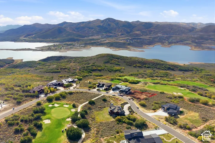 Expansive mountain scenery with a large body of water, golf course frontage, and paved roadways