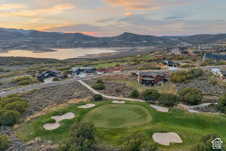 Expansive landscape featuring a golf course, surrounding residential properties, and a large body of water in the background