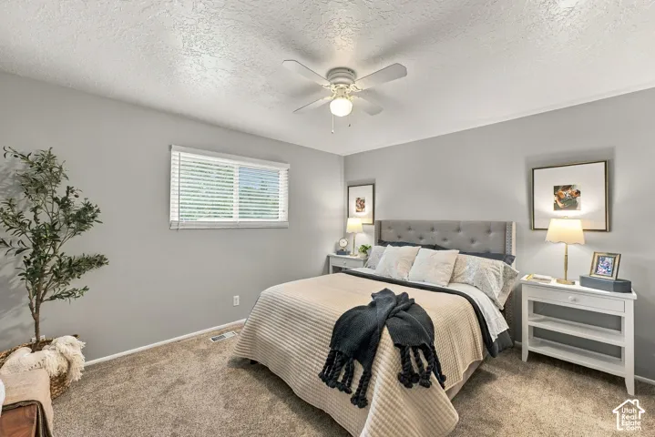 Room featuring neutral wall tones, wall-to-wall carpeting, horizontal blinds, and a white ceiling fan with integrated lighting