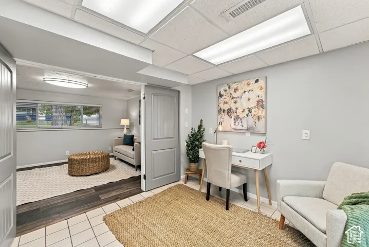 Interior space featuring neutral-toned walls, recessed lighting, tile flooring, wood-finish plank flooring, and a multi-panel door