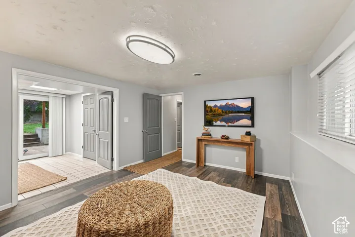 Interior space featuring wood-finish flooring, neutral wall tones, recessed ceiling lighting, multi-panel interior doors, and horizontal slat window blinds