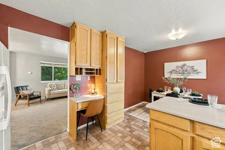 Built-in light-wood cabinetry, integrated desk workspace with overhead storage, and tile flooring