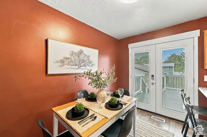 Double glass-paneled doors providing exterior access, tile flooring, and painted wall finishes