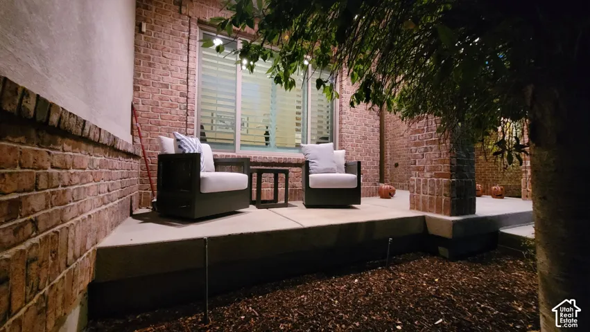 Covered porch featuring brick masonry exterior walls, a concrete patio foundation, and a multi-pane window