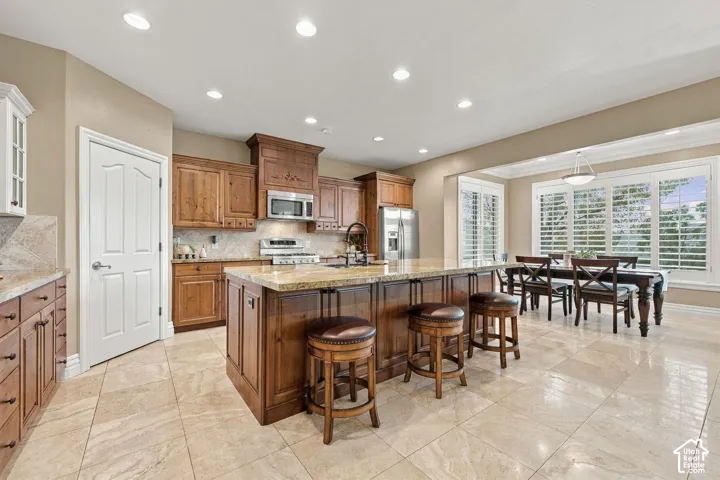 Expansive 9-foot Granite Island with Storage on both sides would easily fit 6 Bar Stools! Shiny Clean Travertine Tile Floors!