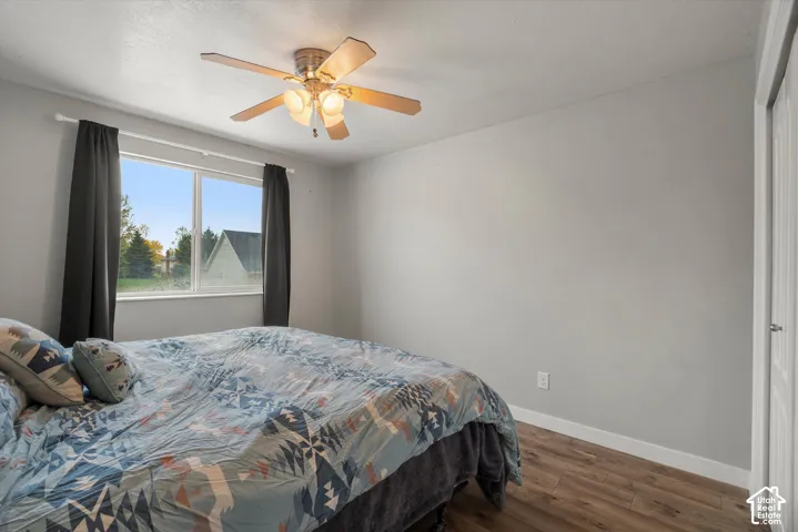 Neutral interior walls, wood-finish flooring, and a ceiling fan with integrated light fixture