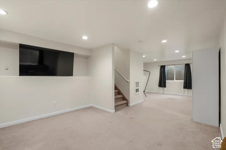 Open interior space featuring recessed ceiling lighting, wall-to-wall carpeting, and neutral wall tones