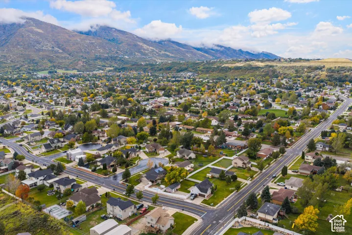 Aerial perspective of residential neighborhood featuring mountain backdrop and mature trees