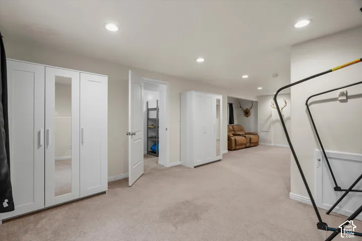 Neutral-toned interior space featuring recessed ceiling lighting, wall-to-wall carpeting, and white paneled doors