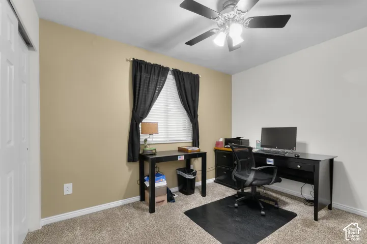 Room featuring neutral wall tones, wall-to-wall carpeting, a multi-blade ceiling fan with integrated light fixture, and a sliding door closet