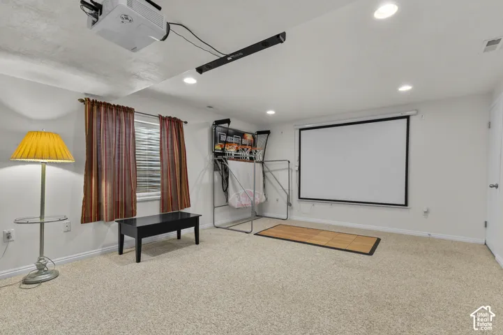 Interior space featuring wall-to-wall carpeting, recessed ceiling lighting, and a ceiling-mounted projector