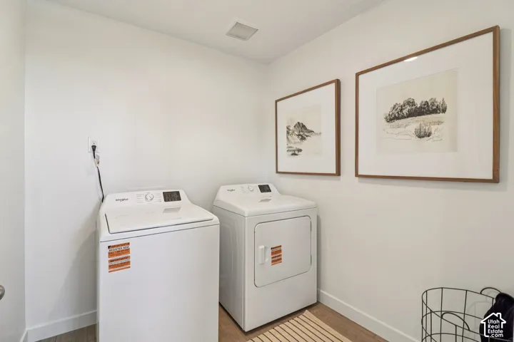Laundry area featuring wood-finish flooring and neutral wall paint