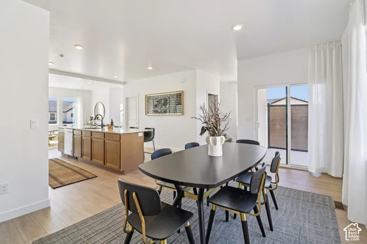 Open-concept area featuring wood-finish flooring, recessed lighting, and a central kitchen island with stone-surface countertops