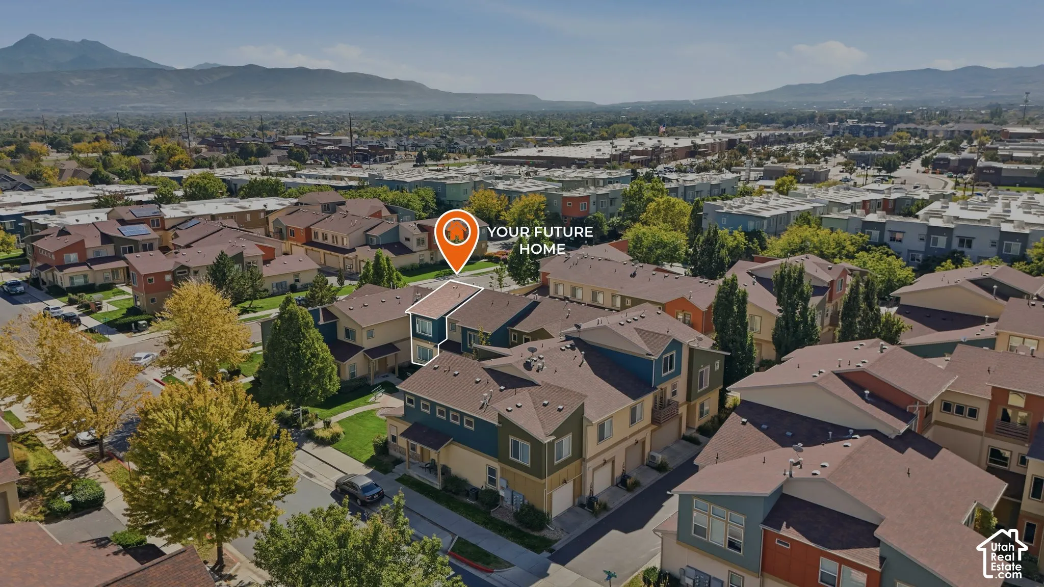 Multi-story residential property featuring a pitched roof, attached garage, and mountain range backdrop