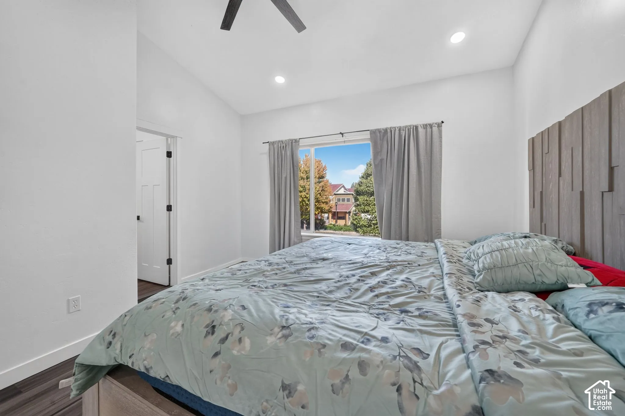Vaulted ceiling featuring recessed lighting, a ceiling fan, and a textured vertical wood-slat accent wall
