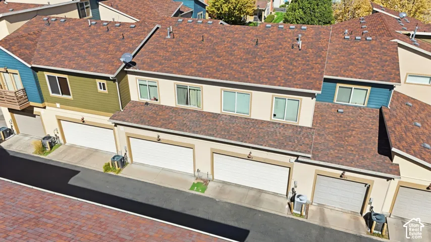 Multi-unit exterior featuring multi-toned shingle roofing, horizontal siding, and integrated multi-car garage bays