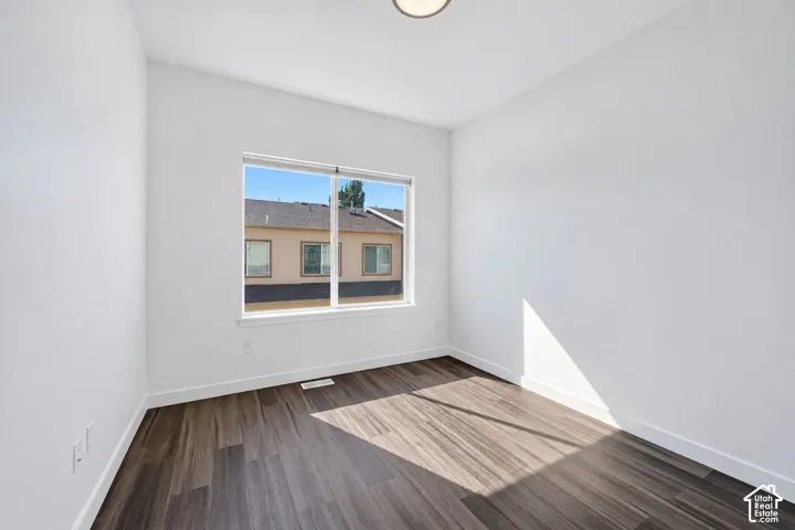 Neutral-toned interior room featuring wood-finish flooring, a large picture window, and recessed ceiling lighting
