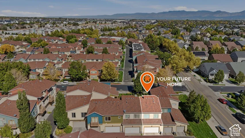 Multi-level townhome featuring a private attached garage, composite shingle roofing, and mountain backdrop