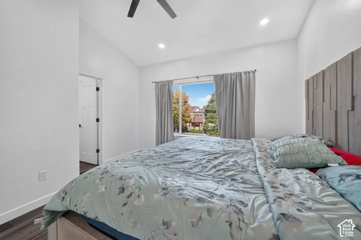 Vaulted ceiling featuring recessed lighting, a ceiling fan, and a textured vertical wood-slat accent wall