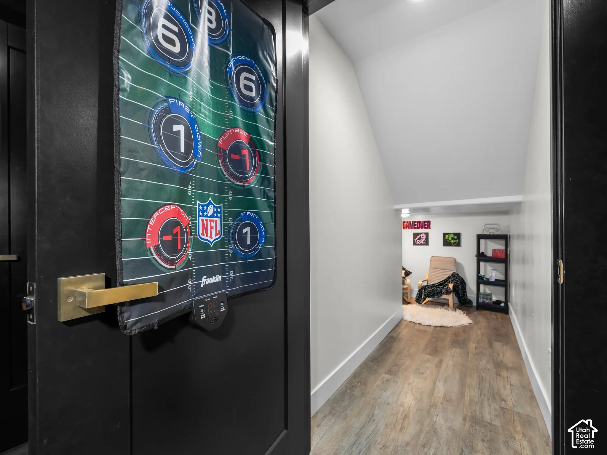 Interior space featuring wood-finish flooring, painted walls, and matte black door hardware with a brass-finish lever handle