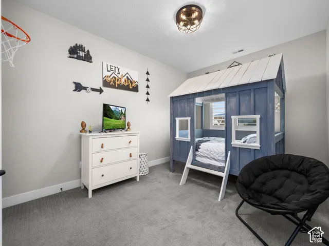 Neutral-toned room featuring wall-to-wall carpeting and a semi-flush mount dome ceiling light fixture