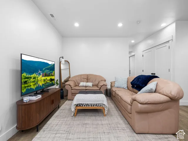Interior space featuring recessed lighting, smooth-finish walls, wood-finish flooring, and double doors with black hardware