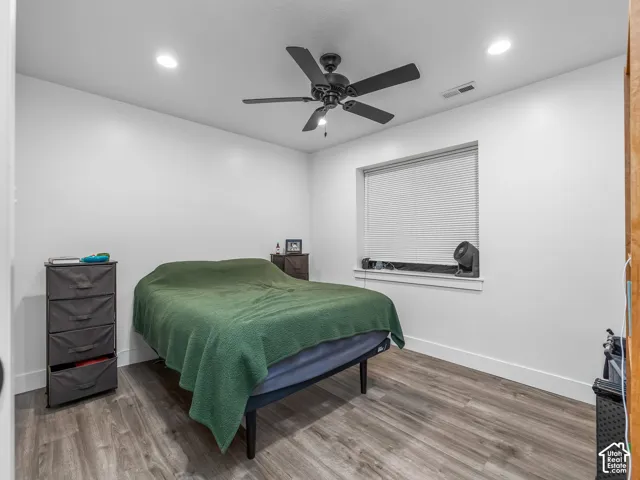 Neutral interior space featuring wood-finish flooring, recessed lighting, and a multi-blade ceiling fan