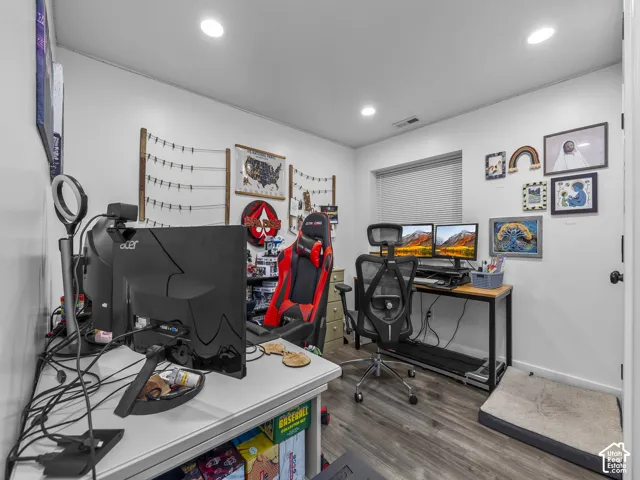 Room featuring neutral-toned walls, wood-finish flooring, and recessed ceiling lighting