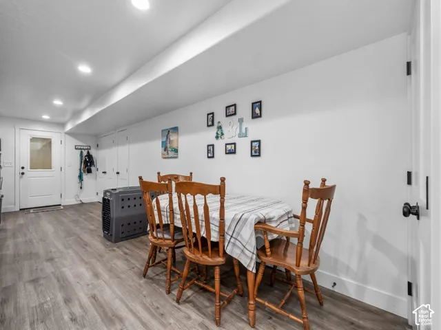 Interior area featuring recessed lighting, wood-finish flooring, white walls, and a glass-panel entry door with dual closet doors