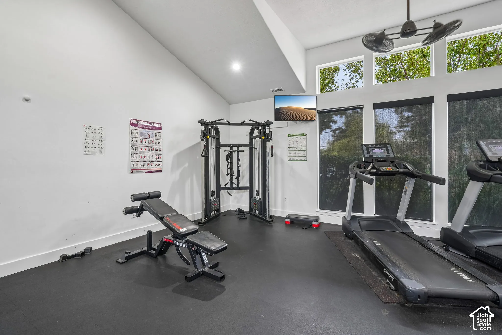 Vaulted ceilings, tall windows with dark roller shades, and durable rubber flooring