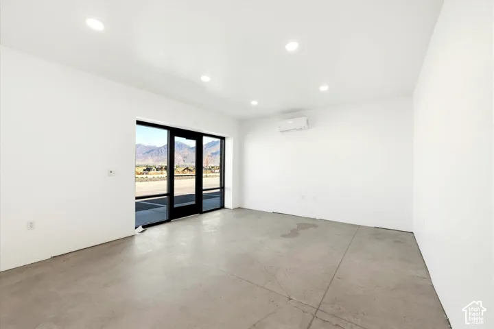 Polished concrete flooring, recessed lighting, and a wall-mounted climate control unit