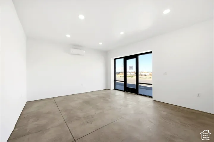 Polished concrete flooring, recessed lighting, and a wall-mounted climate control unit