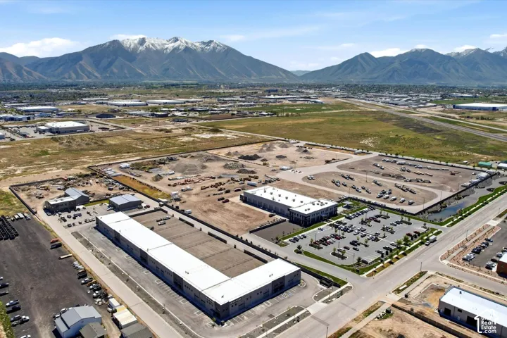 Expansive commercial lots with mountain backdrop, multiple buildings, and surface parking