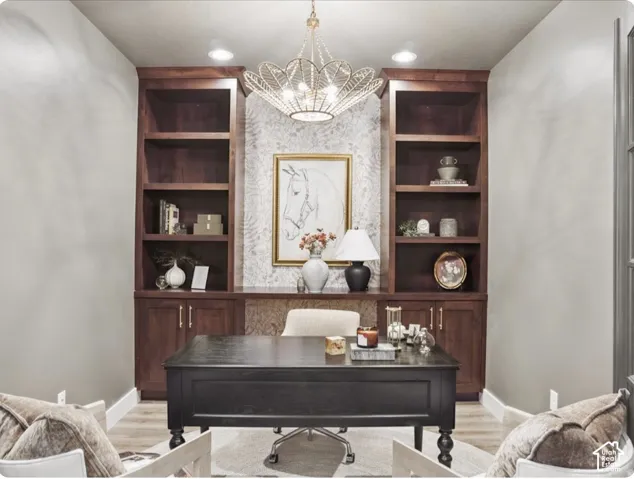 Custom built-in dark wood cabinetry with open shelving and lower storage, ornate metal multi-light chandelier, and decorative wallpaper inlay