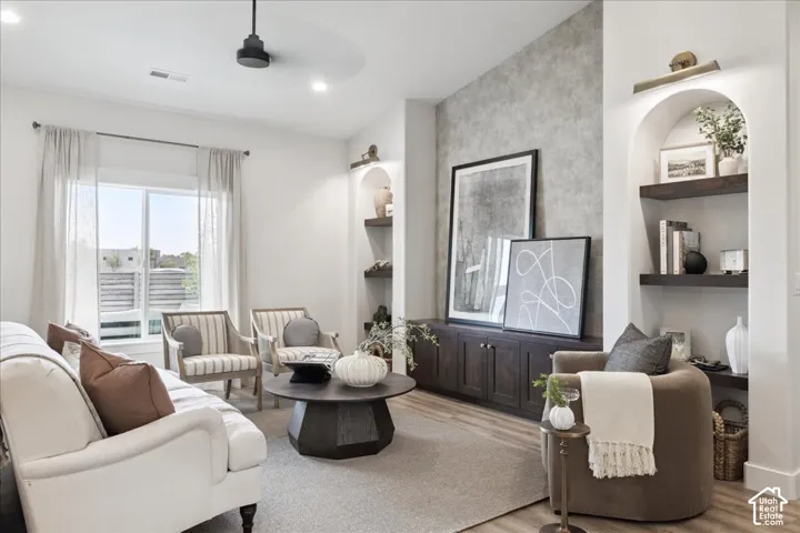 Vaulted ceiling, built-in cabinetry with dark-finish wood, arched wall niches featuring wood shelving, and decorative wall lighting