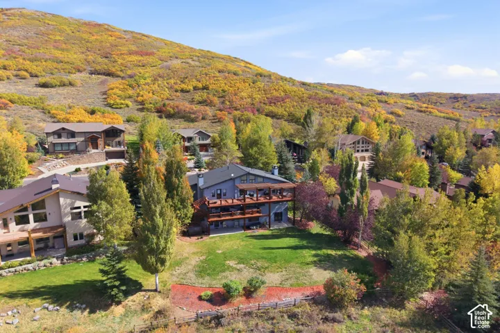 Multi-level home exterior featuring stacked wooden balconies and a hillside location with mountain terrain