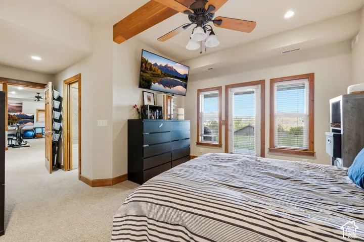 Exposed wood ceiling beam, ceiling fan with integrated lighting, recessed lighting, and wooden window trim