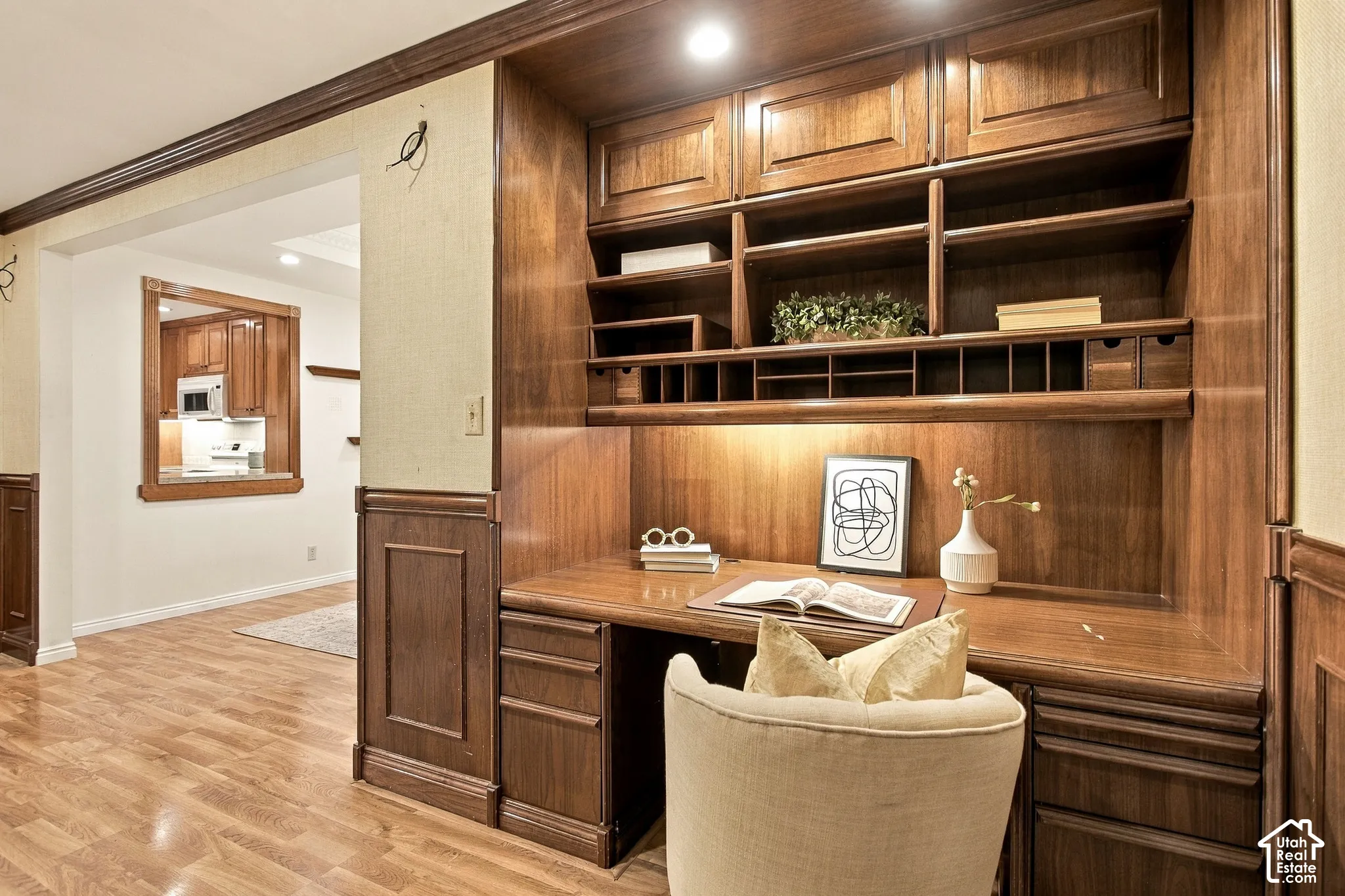 Custom built-in desk featuring wood cabinetry, integrated shelving, pigeonhole organizers, and recessed ceiling lighting