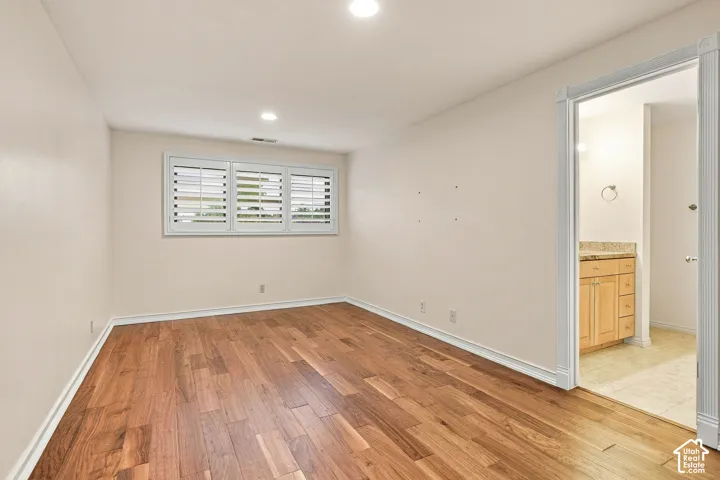 Wood-finish flooring, recessed lighting, and interior shutters featuring a three-panel design