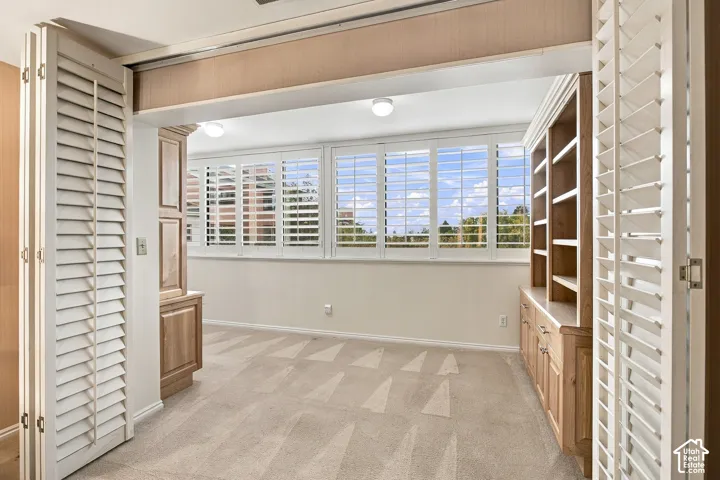 Built-in wood cabinetry, floor-to-ceiling folding louvered shutters, flush-mount ceiling lighting, and expansive multi-pane windows