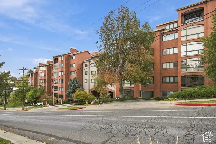 Multi-story brick exterior featuring arched architectural detailing, multi-pane windows, and private balconies