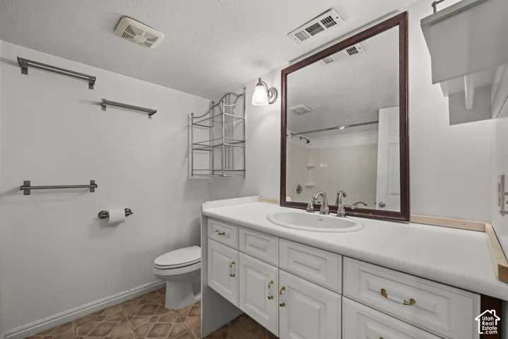 Bathroom featuring a white vanity cabinet with an integrated oval sink, countertop with backsplash, wall-mounted mirror, and multi-drawer storage