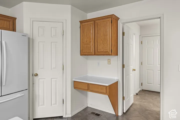 Built-in workstation featuring wood cabinetry, drawers, and a solid-surface countertop