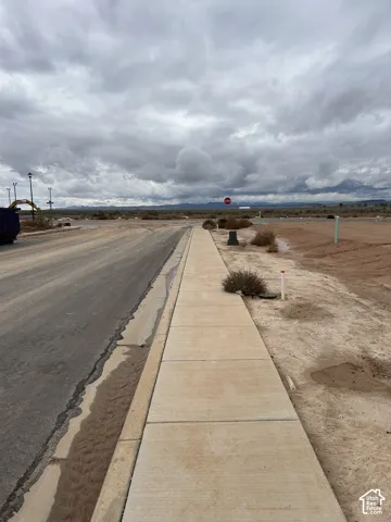Paved street frontage with an integrated concrete sidewalk and mountain horizon
