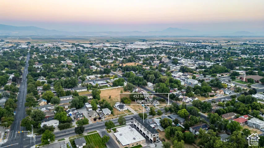 Aerial perspective featuring a multi-level structure with a flat roofline and prominent mountain backdrops
