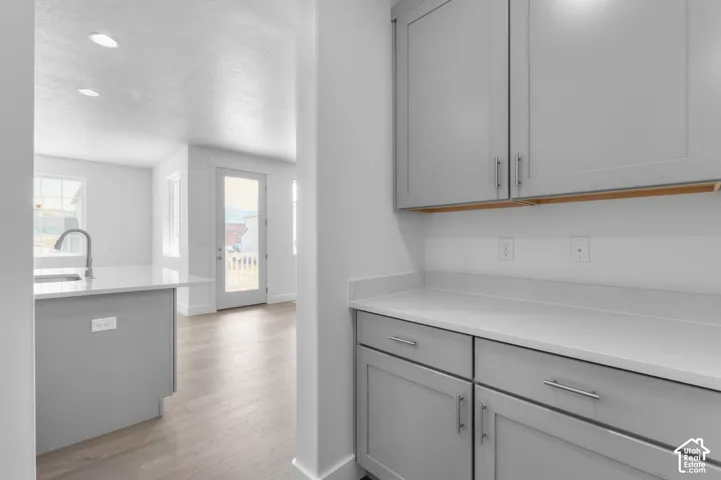 Shaker-style cabinetry, quartz countertops, wood-finish flooring, and recessed lighting