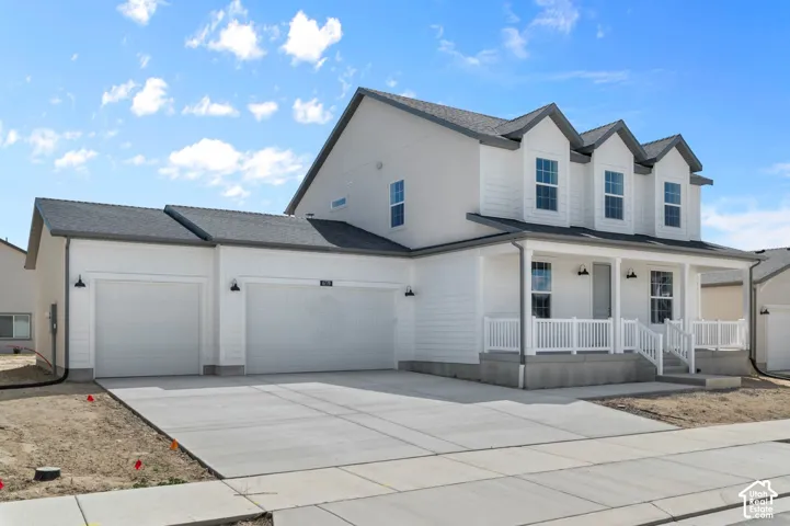 Two-story exterior with horizontal siding, a covered front porch featuring white railing, triple gabled rooflines, and an attached three-car garage